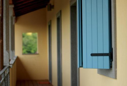 an empty hallway with a blue window on the side of a building at Farmstay Kmetija Štekar in Kojsko