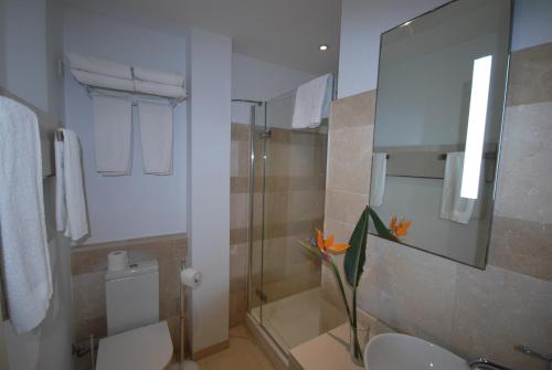 a bathroom with a sink and a toilet and a mirror at Apartamentos Alborada in Cala Millor