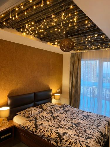 - une chambre avec un lit éclairé au plafond dans l'établissement Sunny Deluxe Apartment Cosmopolis, à Ştefăneştii de Jos