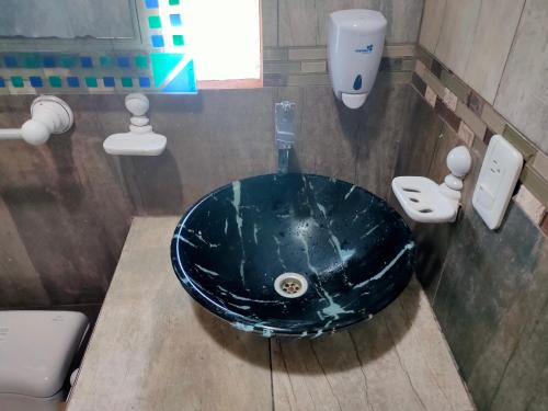 a bathroom with a blue sink and a toilet at Hosteria Mar de Plata in Cabuyal