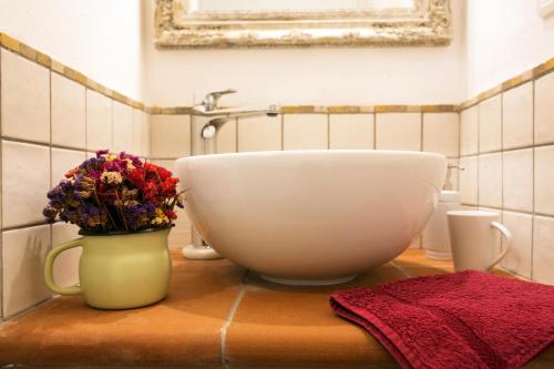 a bathroom with a sink and a vase with flowers at At Home In Maremma in Istia dʼOmbrone