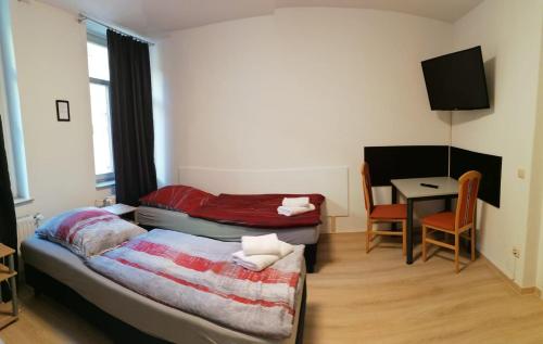 a small room with a bed and a table with a chair at Kunstgasse 11, Wohnung 10 in Altenburg