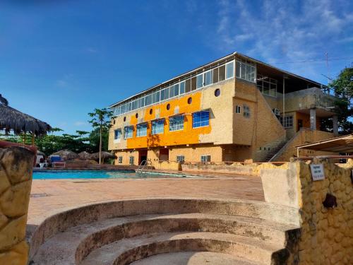 a building with a pool in front of it at Hosteria Mar de Plata in Cabuyal
