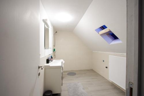 biała łazienka z umywalką i oknem w obiekcie GROGO DUPLEX APPARTMENT(CENTRE OF ANTWERP) w Antwerpii