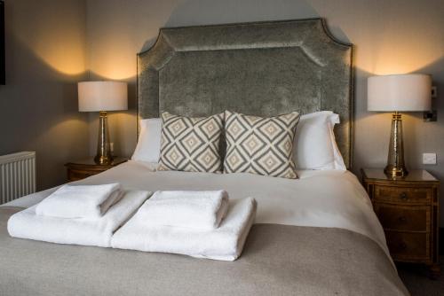 a bedroom with a large white bed with two lamps at Kinnettles Hotel & Spa in St. Andrews