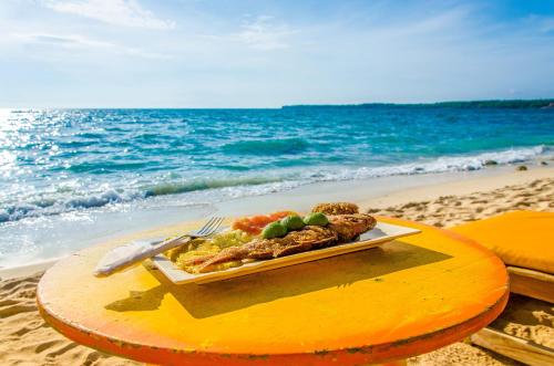 a plate of food on a surfboard on the beach at Nuestros Tres Tesoros II in Playa Blanca