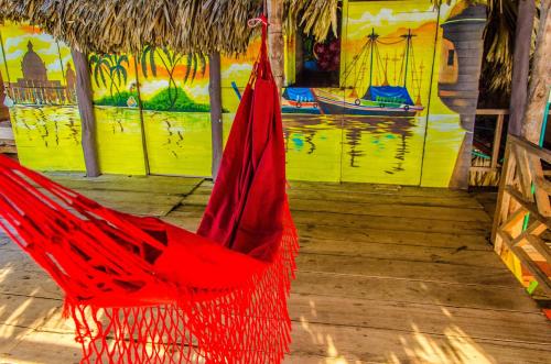 a red hammock on a wooden floor with a painting at Nuestros Tres Tesoros II in Playa Blanca