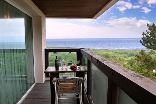 a balcony with a table and a view of the ocean at Minitel Soul in Seogwipo