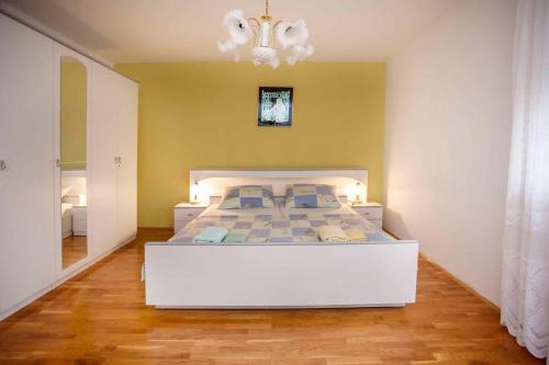 a bedroom with a white bed and a chandelier at Apartment in Rovinj/Istrien 11491 in Štanga