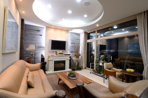 a living room with a couch and a fireplace at Minitel Soul in Seogwipo