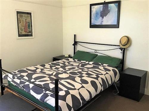 um quarto com uma cama com um edredão preto e branco em Waratah Bay. 21 on Birrahlea em Waratah Bay