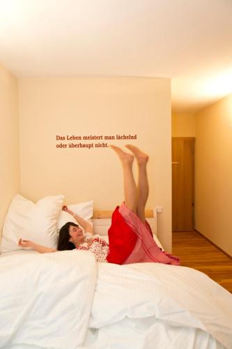 a woman laying on a bed with her feet in the air at Gasthaus Murauer in Simbach am Inn