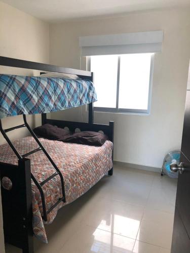 a bedroom with a bunk bed and a window at Departamento Acapulco Diamante in Acapulco