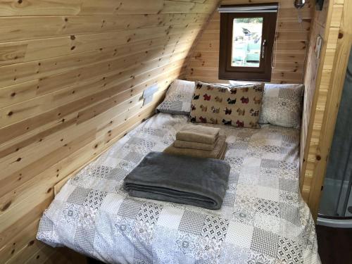 um quarto com uma cama num chalé de madeira em Breakish Bay Pods (Pod 2) em Breakish