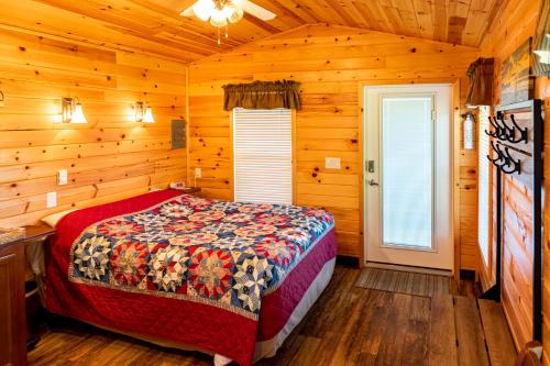 a bedroom with a bed in a log cabin at Crescent Beach and RV Park in Port Angeles