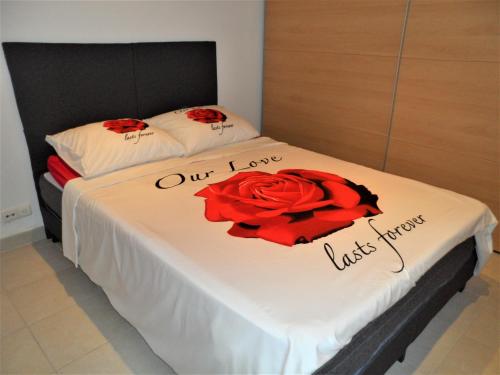 a bedroom with two beds with red roses on them at O ZEE app,garage 200m van strand en centrum in Koksijde