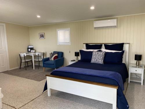 a bedroom with a bed and a table and a chair at Hideaway on Hume #2 in Boonah