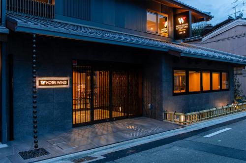 a building with a gate on the side of a street at Hotel Wing International Premium Kyoto Sanjo in Kyoto