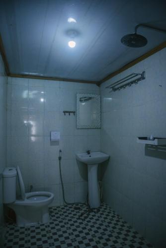 a bathroom with a toilet and a sink at Freddies Santai Sumurtiga in Sabong