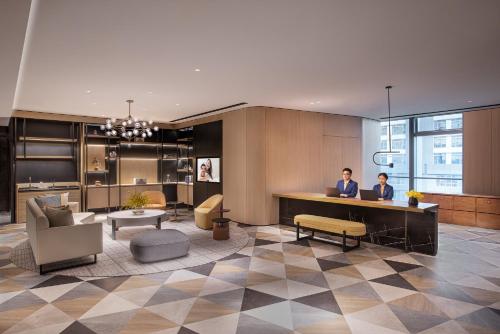 two people sitting at a desk in a lobby at Star Residence ICC Guangzhou in Guangzhou