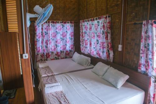 a small bed in a room with windows at Freddies Santai Sumurtiga in Sabong