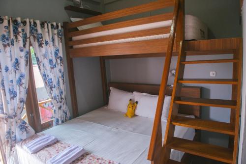 a bunk bed with a ladder in a room at Freddies Santai Sumurtiga in Sabong
