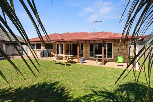 a house with a picnic table in the yard at Mount Holidaze - Mt Maunganui Holiday Home in Matapihi