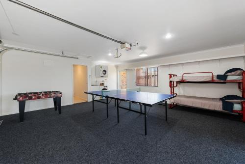 a room with a ping pong table and a bunk bed at Mount Holidaze - Mt Maunganui Holiday Home in Matapihi
