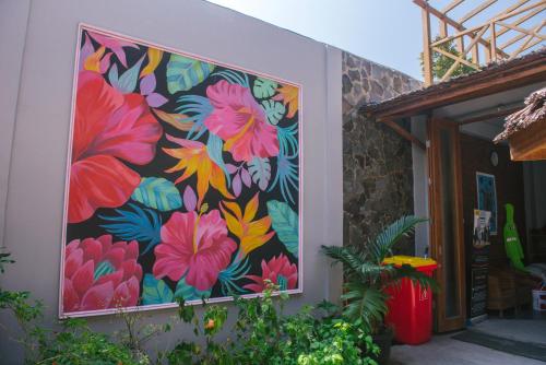 a mural of flowers on the side of a building at Freddies Santai Sumurtiga in Sabong