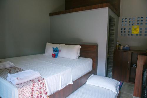 a bed with a stuffed animal sitting on top of it at Freddies Santai Sumurtiga in Sabong