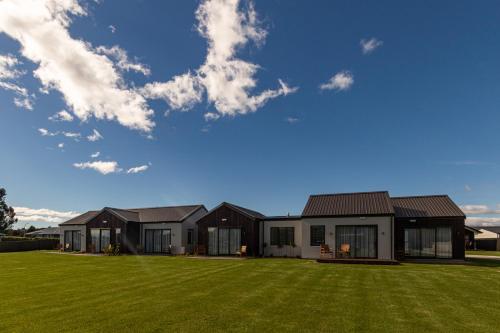 une maison avec une pelouse verte devant elle dans l'établissement Annies on Milford, à Te Anau