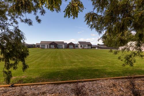 a large lawn with houses in the background at Annies on Milford in Te Anau