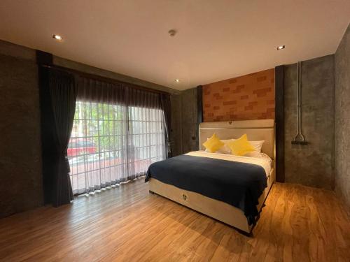 a bedroom with a bed and a large window at Loft122 Hotel in Ban Zong Katiam