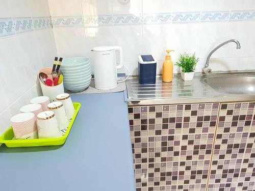 a kitchen with a counter with dishes and a sink at Pangkor Coral Bay Resort(2 bedrooms) in Pangkor