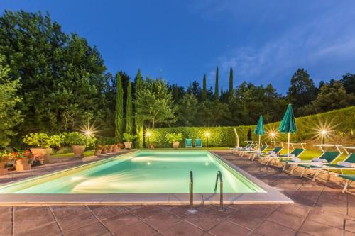 a swimming pool with lawn chairs and umbrellas at Torre Del Cielo in Monterchi