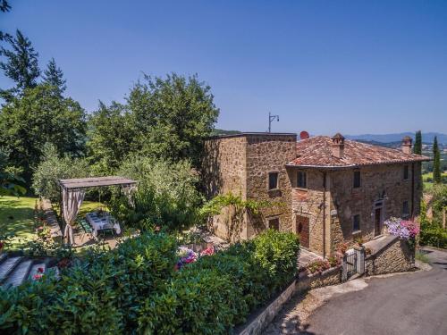 an external view of a stone house with a garden at Torre Del Cielo in Monterchi
