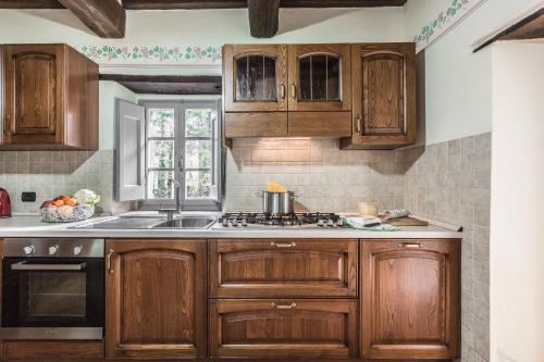 a kitchen with wooden cabinets and a sink at Torre Del Cielo in Monterchi