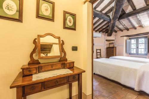 a bedroom with a bed and a mirror on a table at Torre Del Cielo in Monterchi