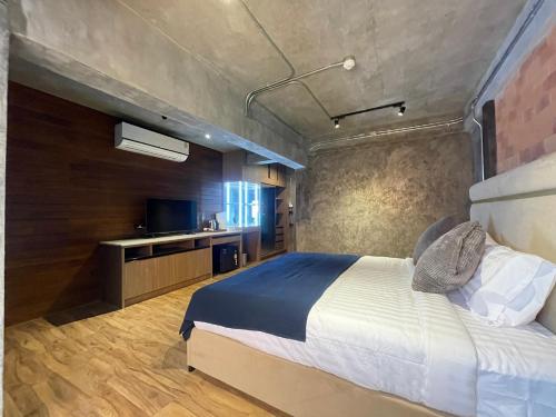 a bedroom with a large bed and a television at Loft122 Hotel in Ban Zong Katiam