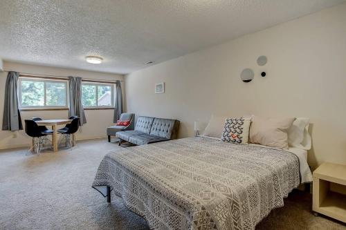 een slaapkamer met een bed en een tafel en stoelen bij Bright & Cozy Studio Apartment in Colorado Springs in Colorado Springs