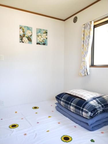 a bedroom with a bed with a pillow on it at Izu Shirada Villa 伊豆白田家 in Higashiizu