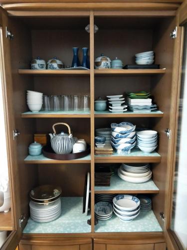 a cabinet filled with plates and bowls and dishes at Izu Shirada Villa 伊豆白田家 in Higashiizu