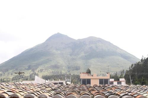 a mountain in front of a building with a roof at Bellavista Casa de Huéspedes in San Pablo