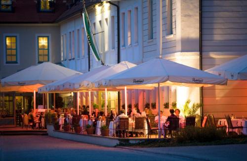 a group of people sitting at tables under umbrellas at Schloss Hotel Dresden Pillnitz in Dresden