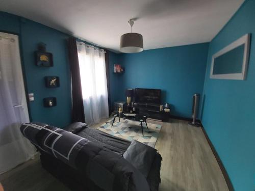 sala de estar con paredes azules y sofá en La Bikok en Billy