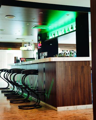 a row ofools at a bar in a restaurant at Holiday Inn Dar Es Salaam by IHG in Dar es Salaam