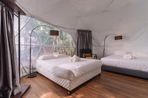 1 dormitorio con 2 camas y ventana grande en Roxy Telok Serabang, en Pelaman Siru
