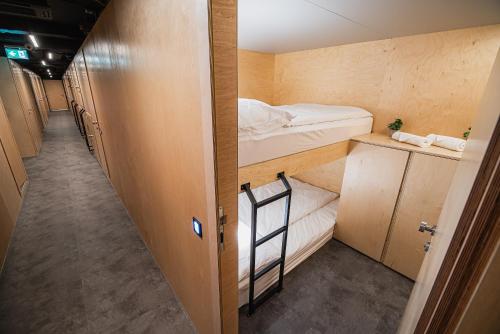 um pequeno quarto com 2 beliches e um corredor em Dragons Dream Hostel em Ljubljana