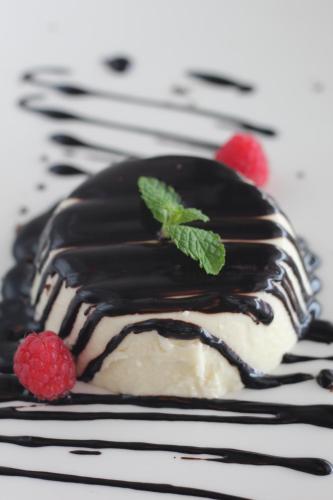 a dessert with chocolate and raspberries on a plate at Hotel Kelly in Rimini