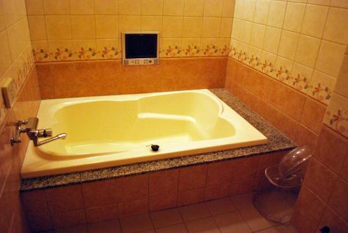 a bath tub in a bathroom with a sink at Ena Hotel Venus in Ena